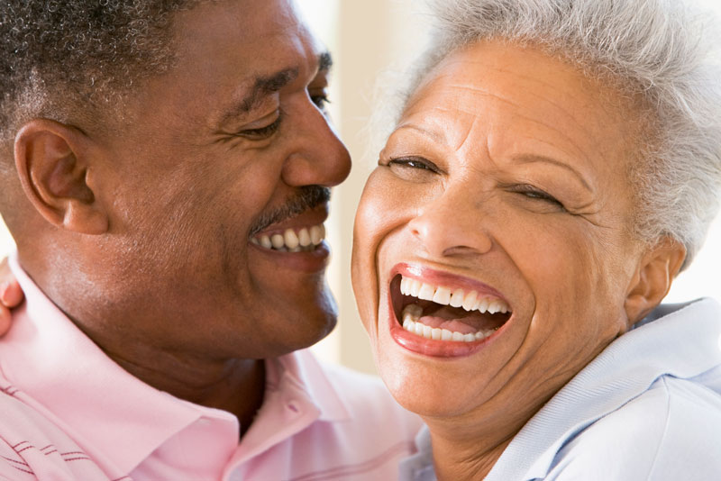 two full mouth dental implant patients embracing in happiness.